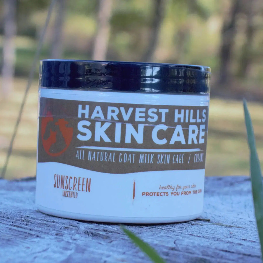 Jar of sunscreen on wood in a natural setting