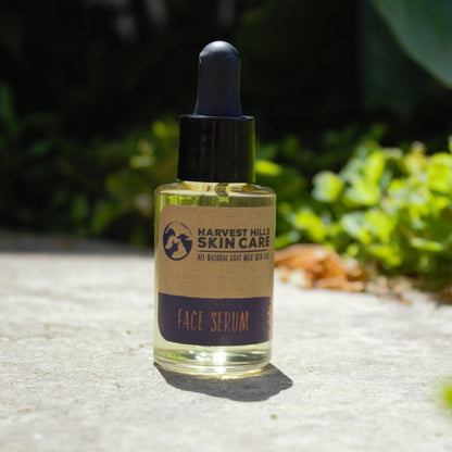 Harvest Hills Skin Care face serum bottle on a stone surface with greenery in the background