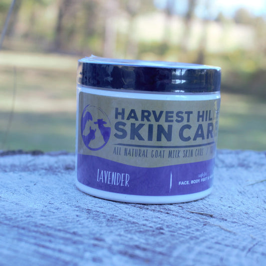 Jar of Harvest Hill Skin Care lavender goat milk moisturizer on a wooden surface with a blurred natural background