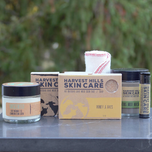 jar of goat milk face cream, bar of goat milk charcoal soap, bar of goat milk honey and oats soap, natural mud mask, natural lip balm, cotton face cloth