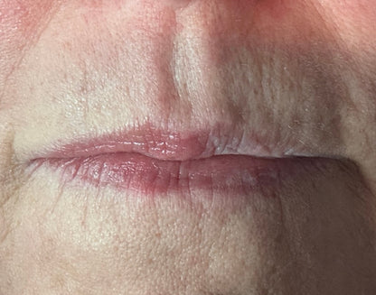 close up of lips with tinted lip balm on half and none on the other half