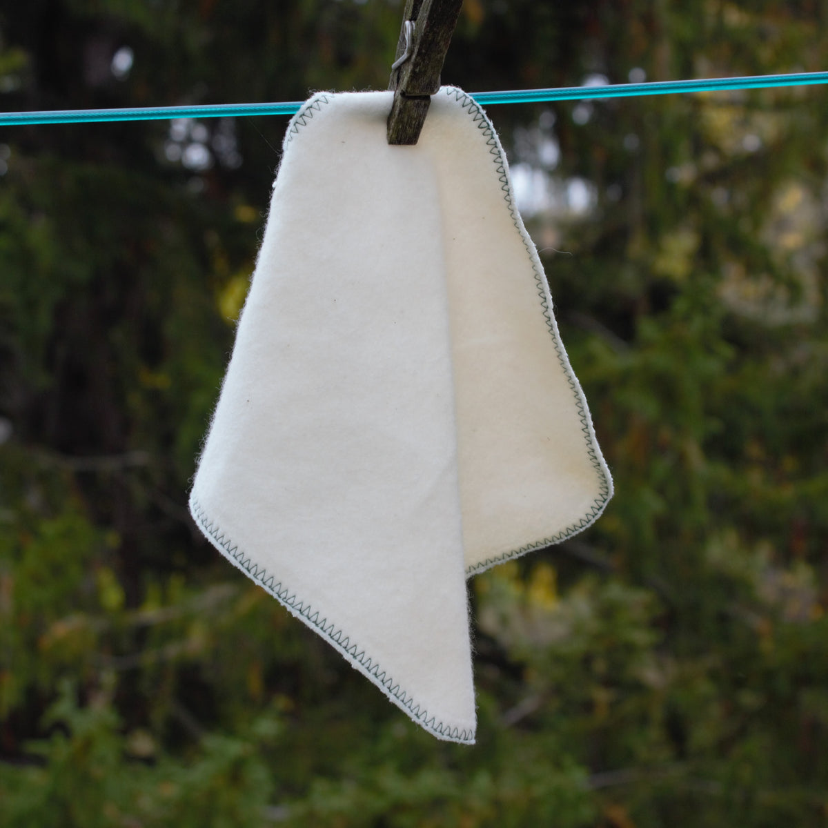 one organic cotton face cloth hanging on a cloths line 