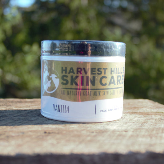 Jar of Harvest Hills Skin Care Vanilla product on a wooden surface with a blurred green background